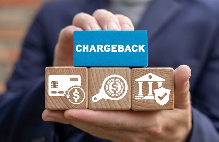 Person holding a block that reads 'chargeback'