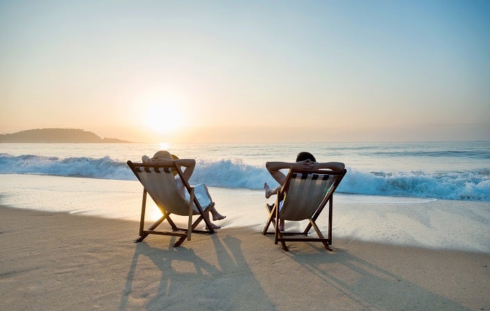 Couple sunbathing on a beach chair. annual leave holiday employee benefits