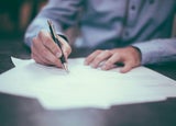 A person is signing a contract with a pen.